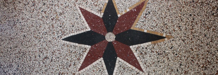 Mehrfarbiger Stern im Terrazzo und umlaufenden Mosaik